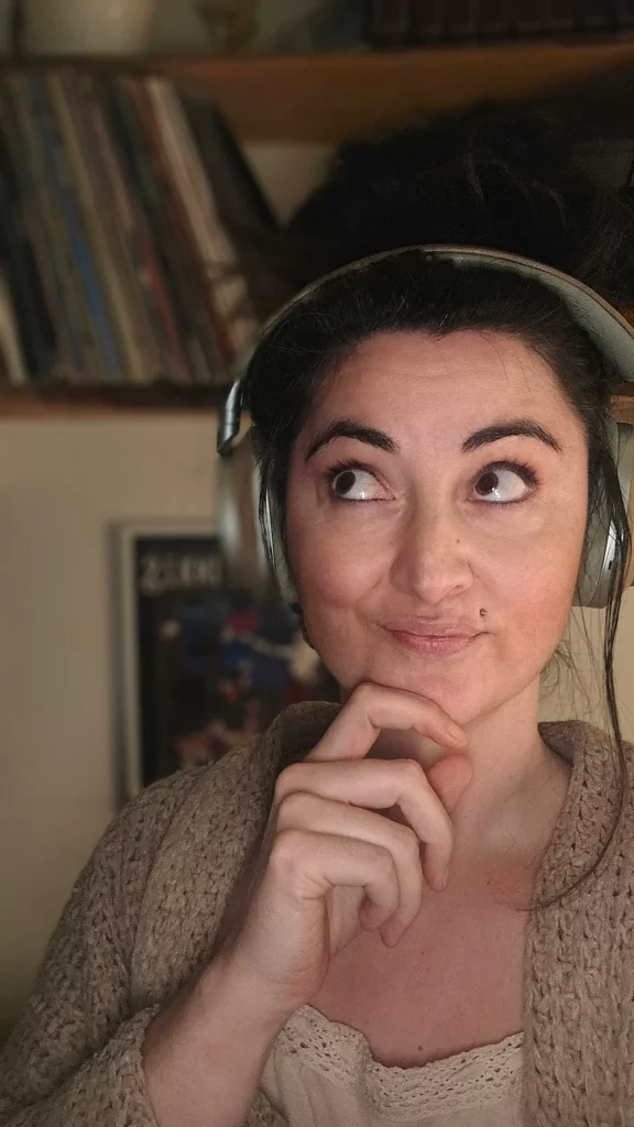 Federführerin Katha Gritsch trägt Kopfhörer, im Hintergrund unscharf ihr Plattenregal